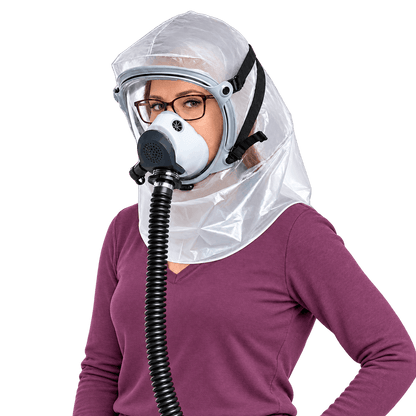 Woman wearing eyeglasses inside an Israeli Sapphire CBRN PAPR hood with a connected powered-air breathing hose