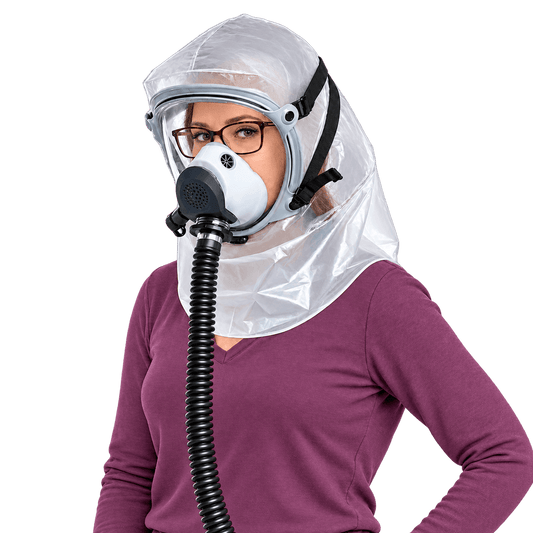 Woman wearing eyeglasses inside an Israeli Sapphire CBRN PAPR hood with a connected powered-air breathing hose